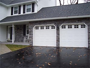 Stone veneer accenting front porch and garage doors of house